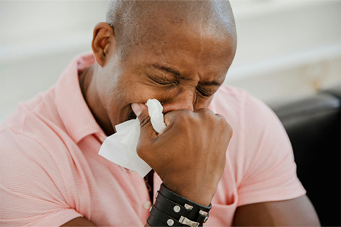 Man in a pink shirt looking emotional and wiping tears with a tissue, reflecting heartbreaking casino worker stories.