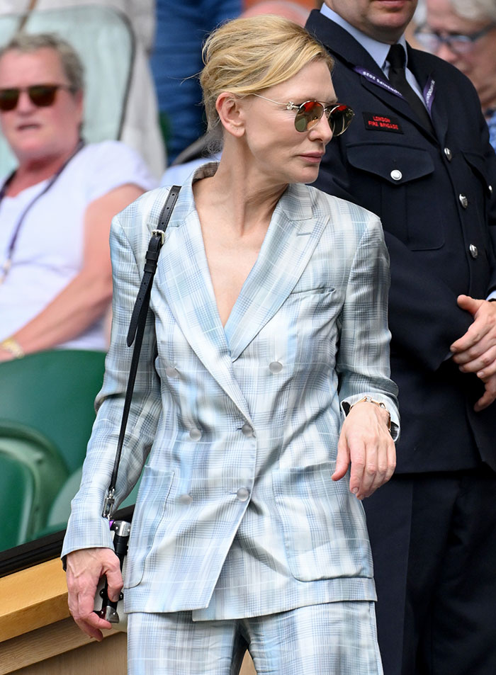 Woman in a light blue plaid suit wearing sunglasses at Wimbledon 2025, showcasing celebrity fashion looks.