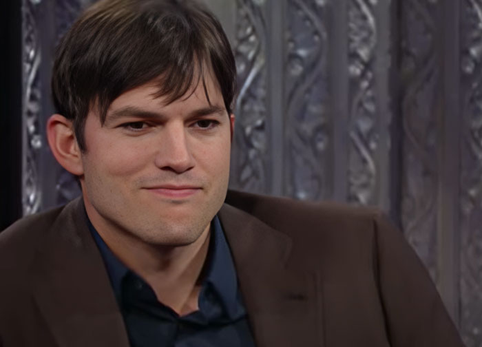 Man in a brown jacket discussing wild things celebrities have done after a breakup in a studio interview setting. - 8