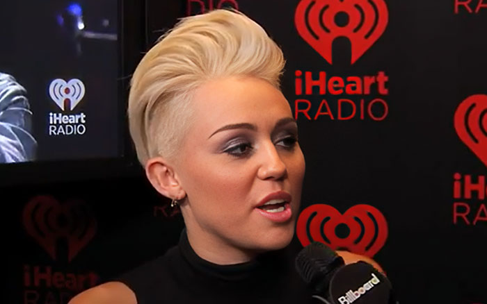 Celebrity with platinum blonde hair speaking into a microphone at an iHeartRadio event discussing breakup wild things. - 28