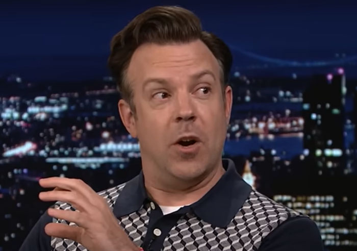 Man in a patterned shirt speaking on a late night show about wild things celebrities have done after breakups. - 23