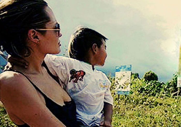 Woman wearing sunglasses holding a child outdoors, illustrating celebrity wild things they do after a breakup. - 16