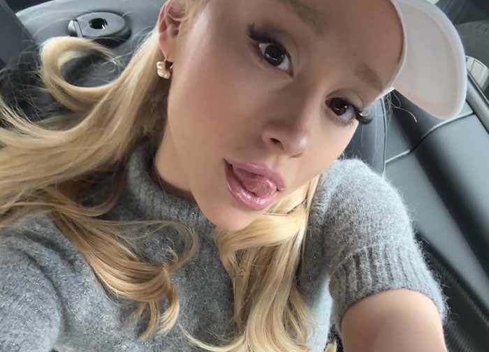 Blonde woman wearing a white cap and gray sweater taking a selfie in a car, illustrating celebrity breakup reactions. - 21