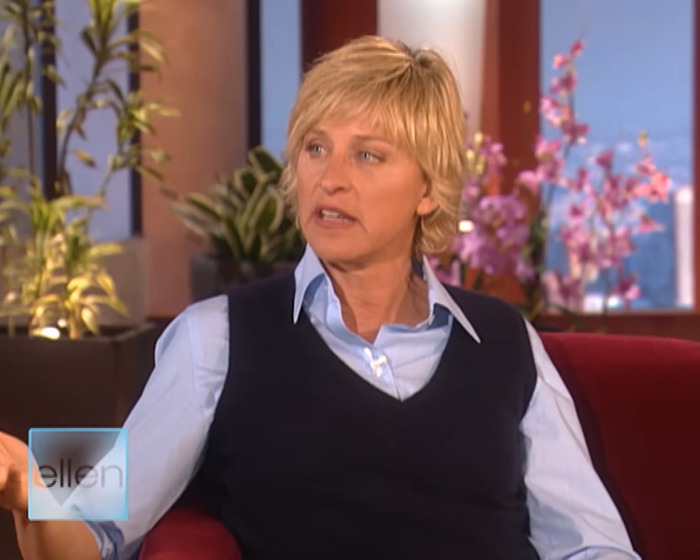 Ellen DeGeneres speaking during a talk show interview, with plants and flowers in the background. - 1