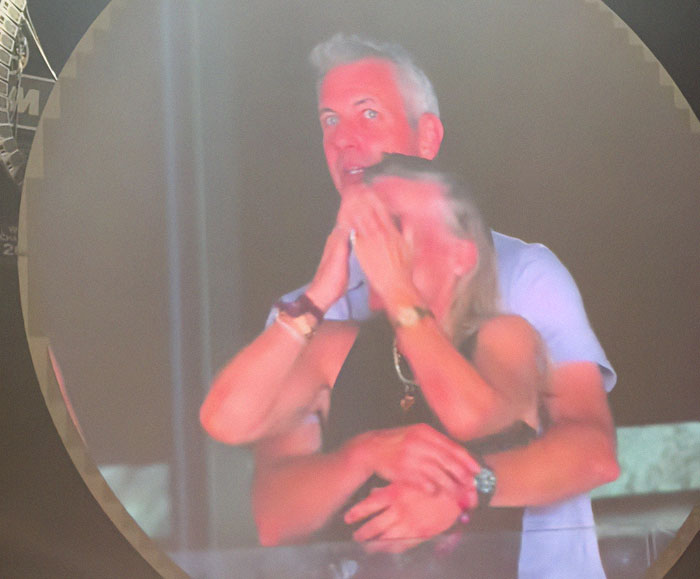 Couple at a Coldplay concert amid scandal involving wife of CEO accused of cheating and social media profile deletion.