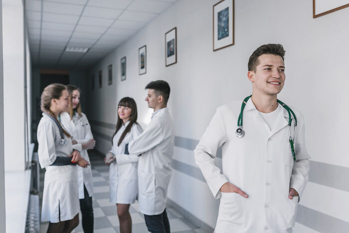 Group of medical professionals in white coats standing in hospital hallway, related to people who deal with dead bodies.
