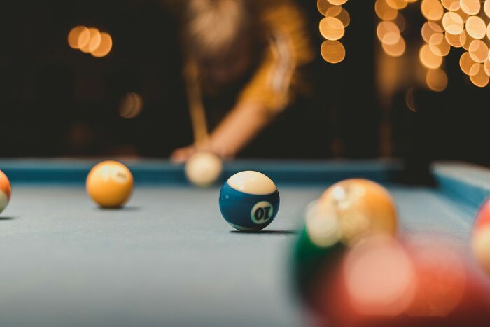 Person playing billiards with colorful balls on a pool table, related to items found in or on patients that made medical professionals gasp