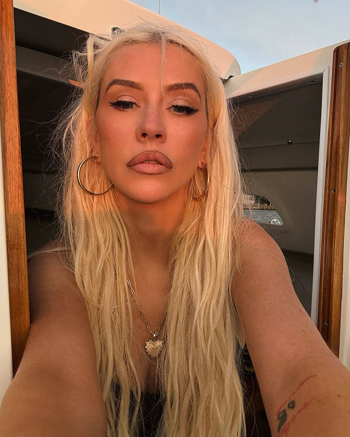 Christina Aguilera with long blonde hair and hoop earrings poses for a racy photoshoot fueling Ozempic rumors. - 1
