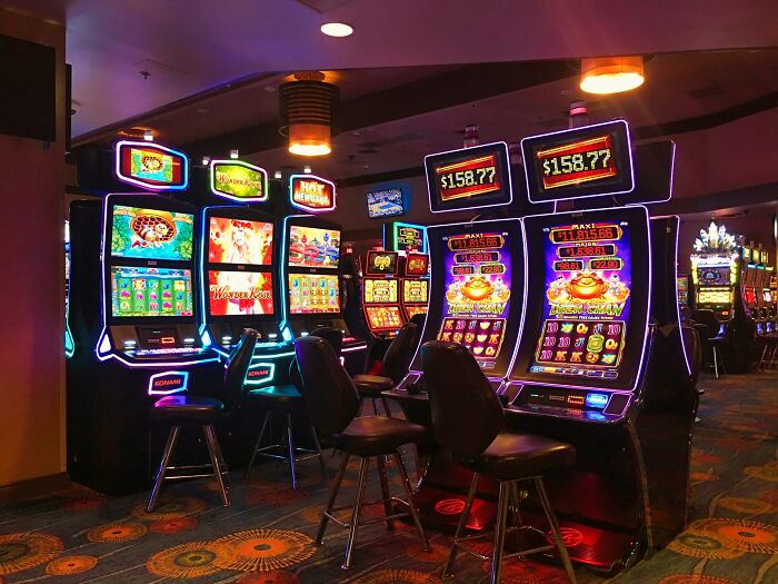 Slot machines lit up inside a casino, illustrating jobs that can make 6 figures in unique industries.