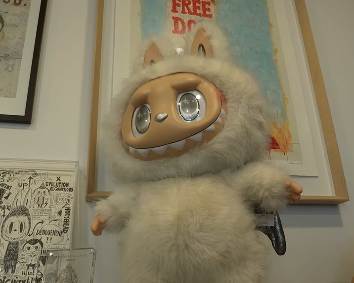 Plush Labubu doll with large eyes in a furry white costume, highlighting Labubu dark conspiracy concerns.