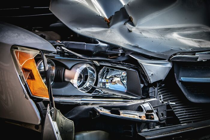 Close-up of a car's damaged front headlight and hood after a crash, highlighting gut feeling that saved lives.