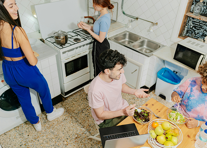 College students cleaning and eating together in a kitchen, encouraged by their only female roommate being petty. - 24
