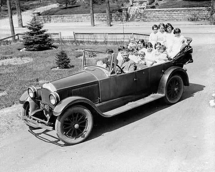 Vintage photo of a large group of people in an old car, showcasing unique old photos and their incredible stories.