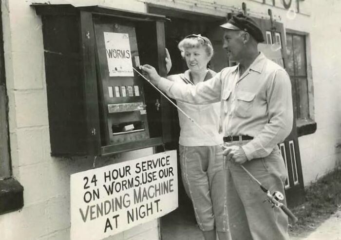 Vintage black and white photo of a couple using a 24-hour worm vending machine, showcasing unique old photos.