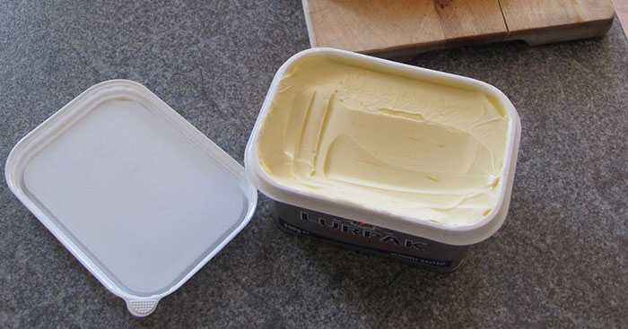 Open container of butter on kitchen counter, related to washing chicken and debunking cooking myths online.
