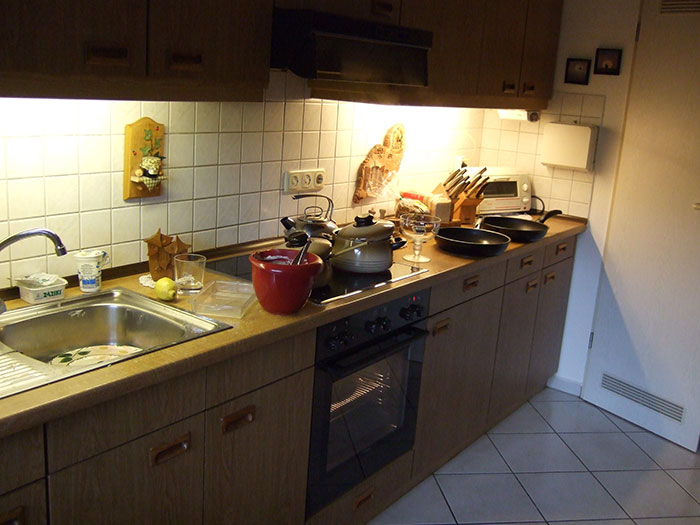 Kitchen countertop with pots, pans, and utensils, illustrating common cooking practices including washing chicken debate.