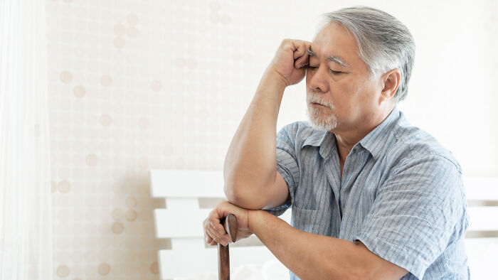 Elderly man sitting indoors looking thoughtful, illustrating unusual calls first responders have encountered.