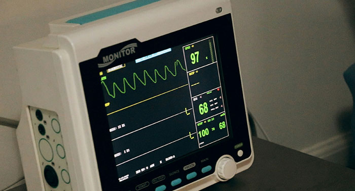 Medical monitor displaying vital signs in a clinical setting highlighting condition survival of 70 people.