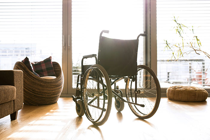 Wheelchair in sunlit modern living room symbolizing medical professionals surprised by patient survival.