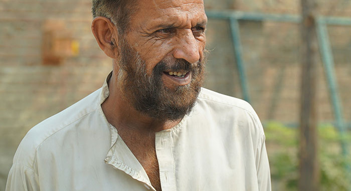 Elderly man smiling outdoors, showing signs of survival despite serious medical condition, surprising medical professionals.