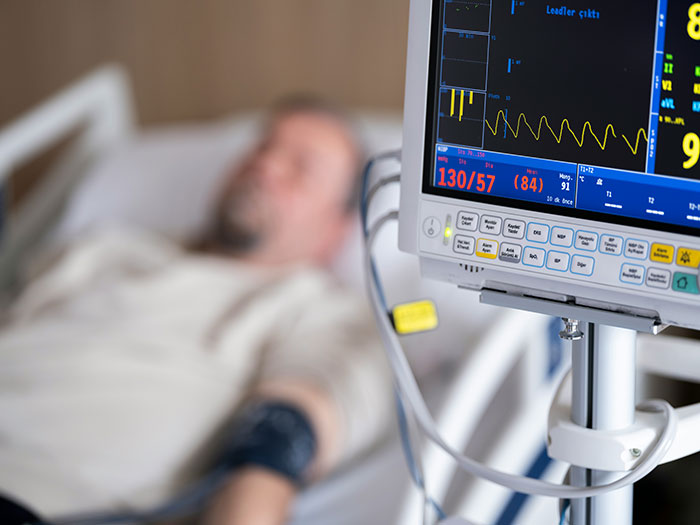 Hospital patient connected to medical monitors showing vital signs, highlighting medical professionals surprised by survival cases.