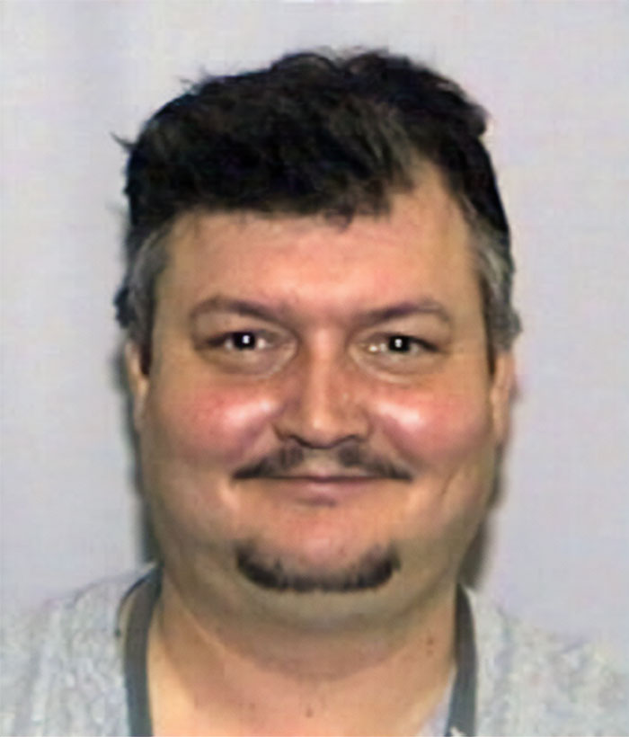 Mugshot of a man with dark hair and facial hair, related to creepy and terrifying facts in a disturbing context.