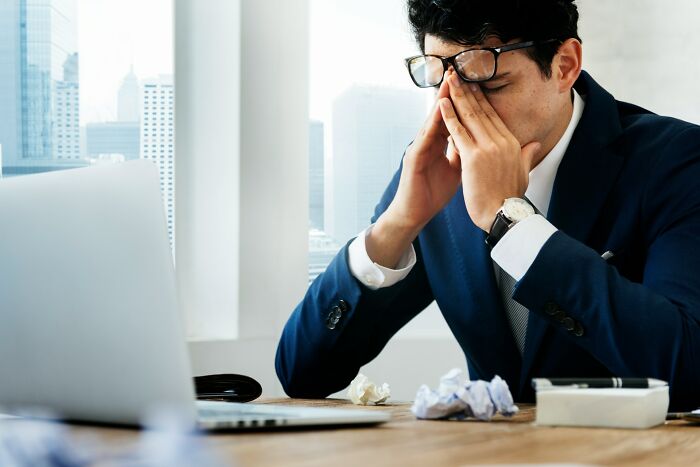 Stressed businessman at office desk with laptop, illustrating tension tied to the internet on the brink of collapse. - 6