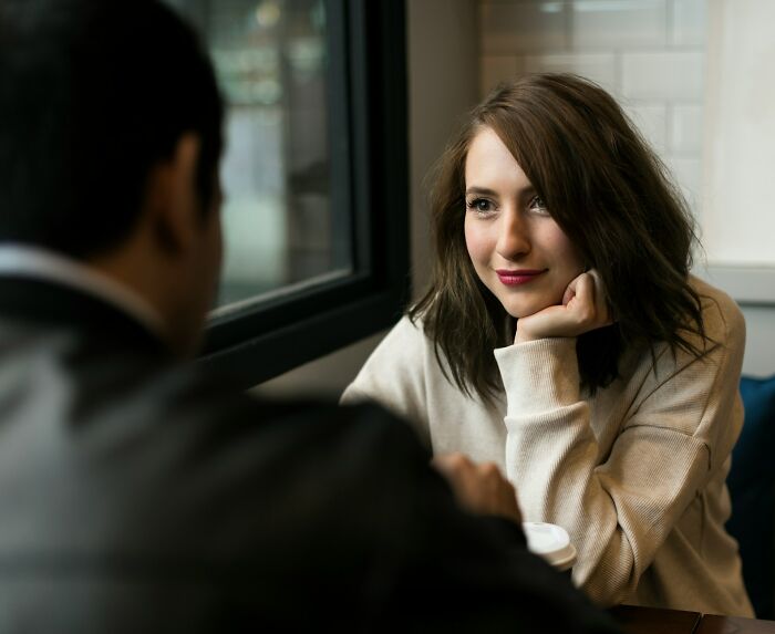 Young woman engaging in a candid conversation with a man, reflecting on toxic best friends in a cozy environment. - 55