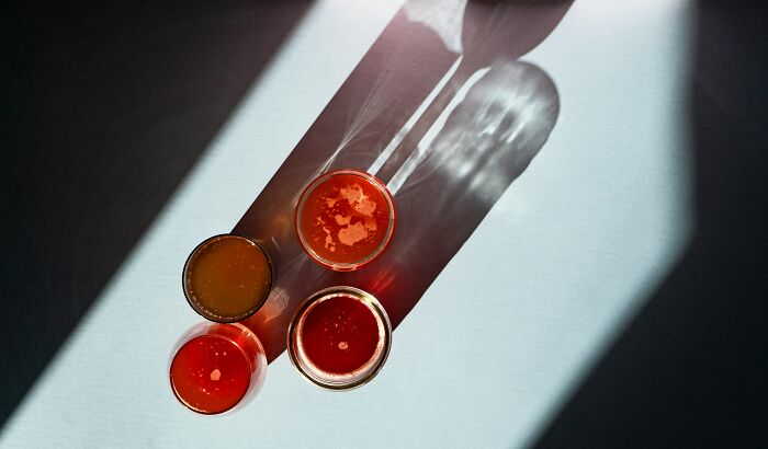 Top-down view of four McDonald's sauce containers casting shadows on a white surface, relating to employee experiences.