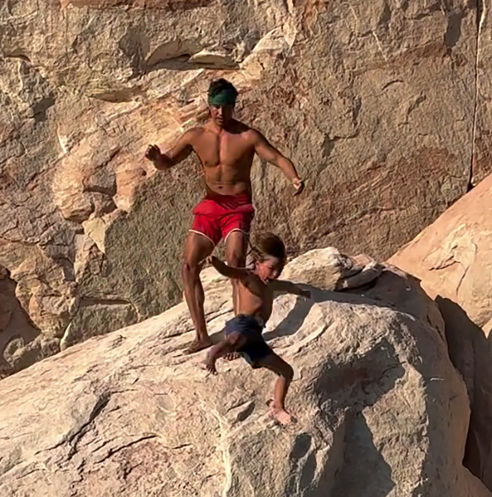Man in red shorts throwing 7-year-old son off cliff to teach him to face his fears, sparking public outrage. - 6