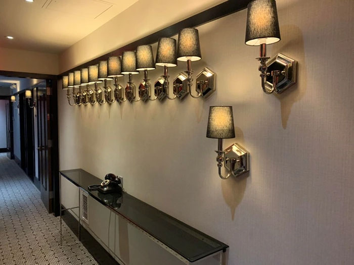 Wall lamps in a hallway, unevenly spaced and misaligned, illustrating imperfect things that annoy people with OCD.