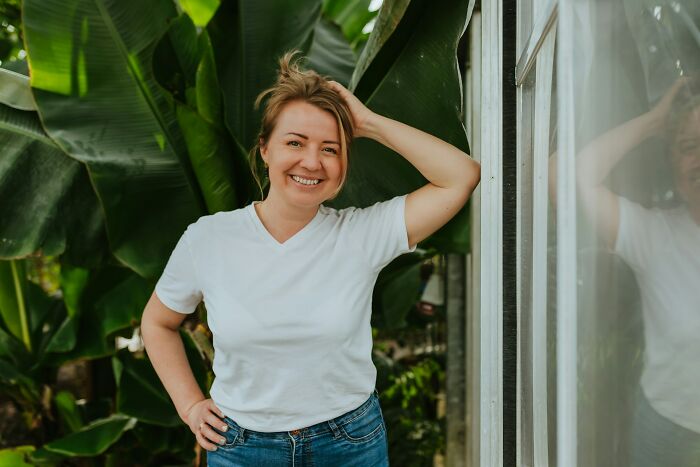 Smiling older woman wearing a white shirt standing outdoors near plants, reflecting life after divorce and new beginnings. - 21