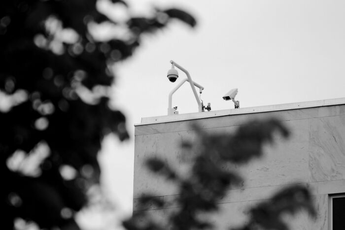 Security cameras mounted on a building rooftop capturing footage, related to interesting rumors that turned out true.