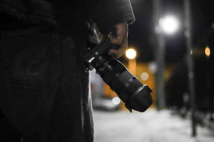 Person holding a professional camera at night capturing weird and terrifying details related to people who deal with dead bodies.