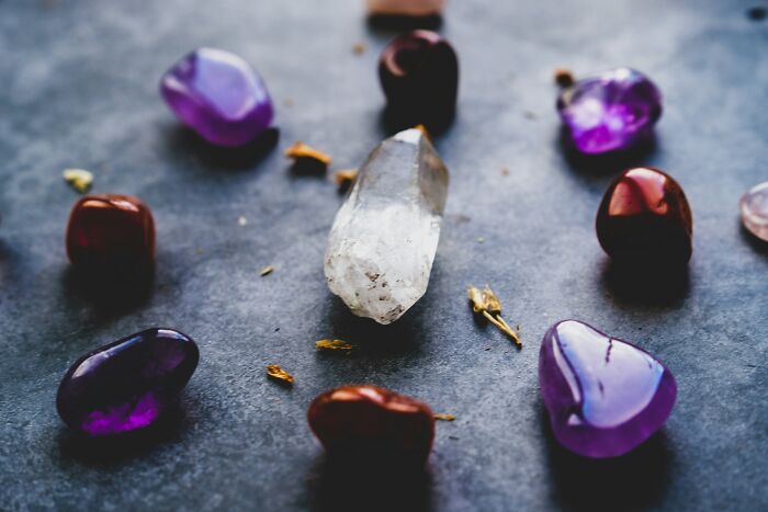 Clear quartz and amethyst crystals arranged in a circle on a dark surface, representing common bizarre beliefs. - 12