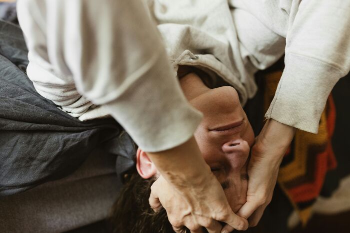 Person lying down with hands on forehead, illustrating the struggles of antidepressant withdrawal symptoms.