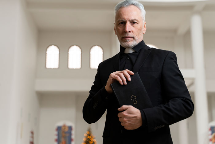Middle-aged pastor holding a Bible inside a church, preparing for daughter church camp in Houston event.