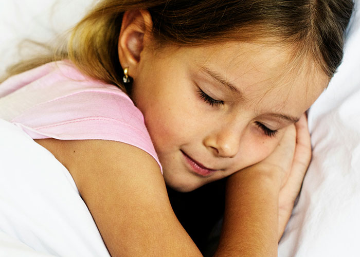 8-year-old girl sleeping peacefully at mom's boyfriend's house, illustrating child spending the night away from dad's presence.
