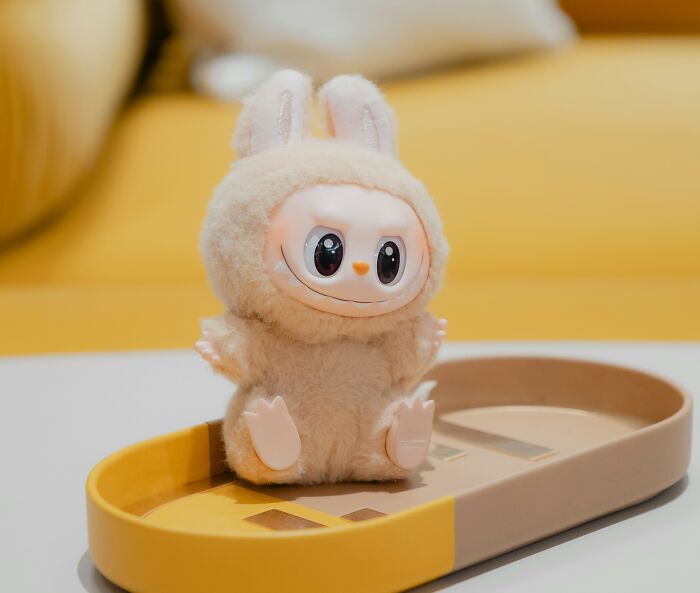 Plush toy with bunny ears sitting on a yellow and beige tray, representing trends contributing to overconsumption concerns. - 8