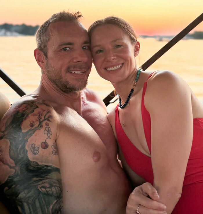 Dax Shepard and wife Kristen Bell smiling for a selfie near water at sunset, showcasing a relaxed and intimate moment.