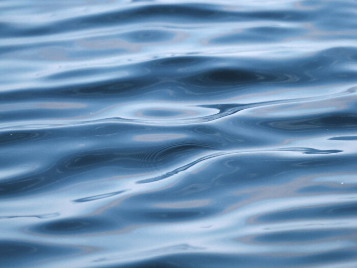 Close-up of calm water surface showing smooth ripples, illustrating silent things deaf people often assume are noisy.