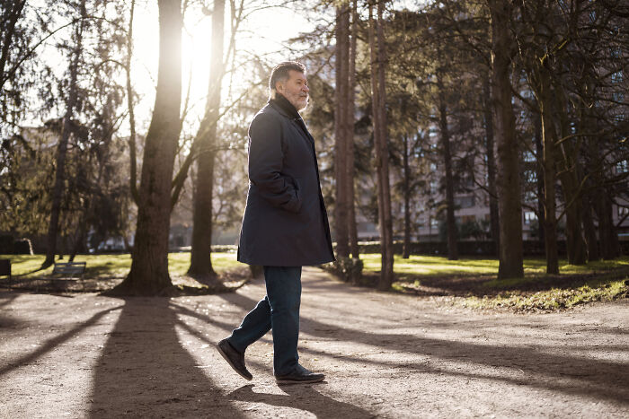 Man walking quietly in a sunlit park, illustrating deaf people’s perspective on surprisingly silent things assumed noisy.