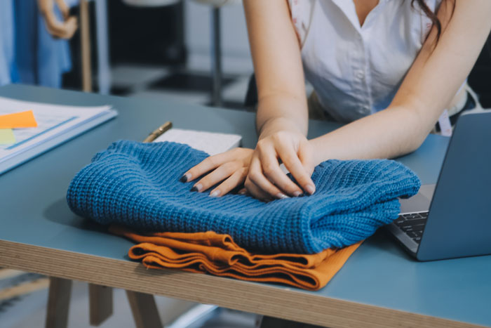 Woman examining fabric on table, distressed over beloved $25 yard fabric ruined by guest’s kids at home. - 19