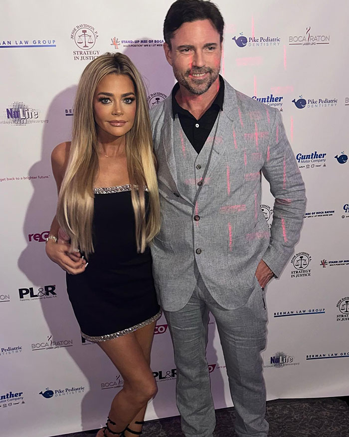 Denise Richards at event with man in gray suit, relates to Denise Richards accuses estranged husband of assault news. Denise Richards at event with man in gray suit, relates to Denise Richards accuses estranged husband of assault news.