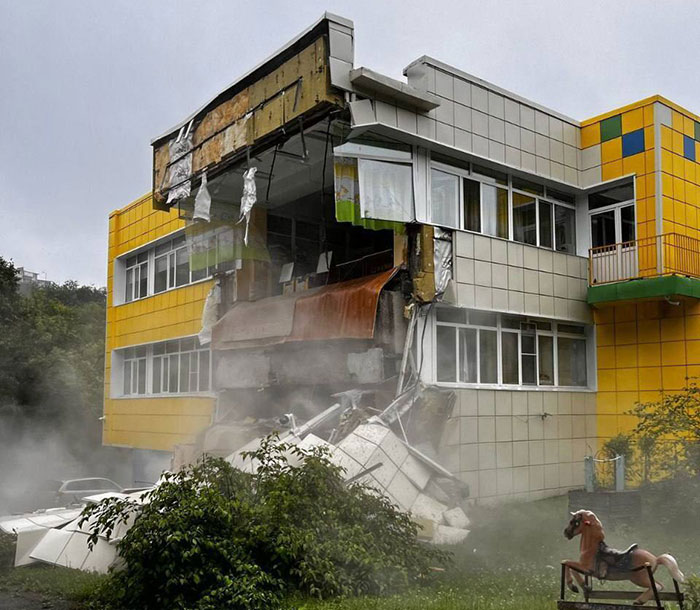 Partially collapsed building with debris and smoke, illustrating damage amid tsunami evacuation controversy involving Oprah. - 2