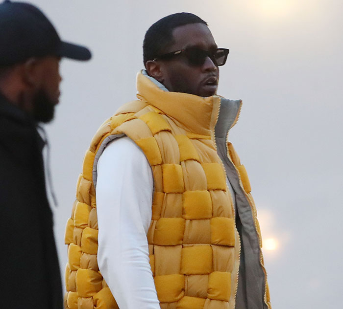 Diddy wearing a yellow puffer vest and sunglasses as his trial turns chaotic with a surprise jury note after deliberations.