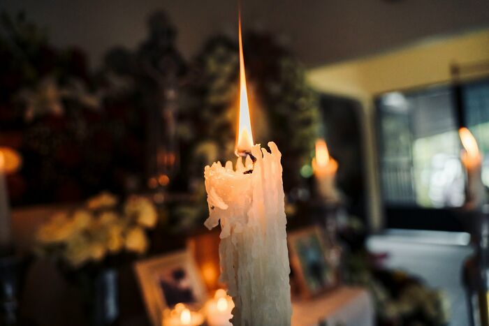 Close-up of a melting candle flame in a dim room, symbolizing somber moments linked to messed up school incidents. - 27