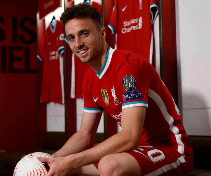 Young football player in red jersey sitting in locker room holding a soccer ball, related to stars we've lost this year.