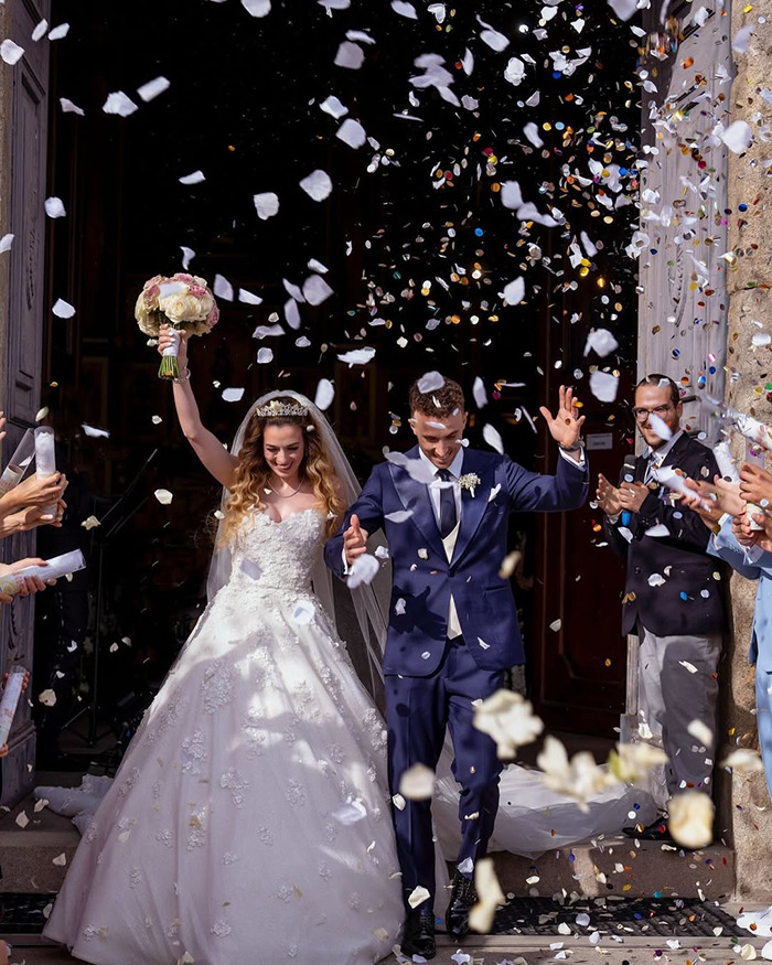 Bride and groom celebrating outside a church with confetti falling, symbolizing a reminder of life's fragility and heartbreak emotions.