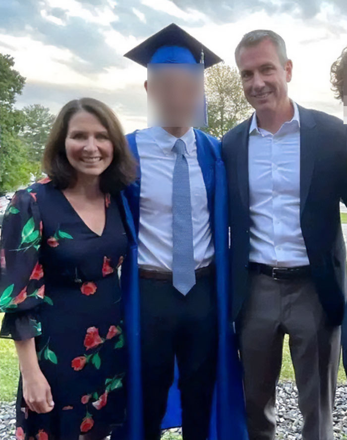 Man in graduation gown and cap standing between two smiling adults outdoors at sunset, relating to CEO Andy Byron lawsuit.